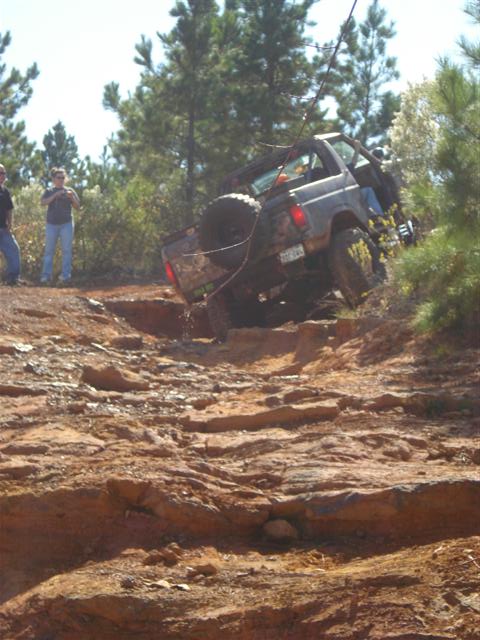 2008 International School Bus - An off-road vehicle is seen navigating a challenging rocky terrain, with a spare tire mounted on its rear.