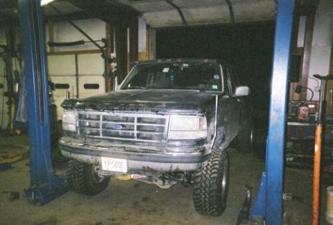 1994 Ford F-150 - This black 1994 Ford F-150 is shown on a lift in a garage, with its front grille and license plate clearly visible.