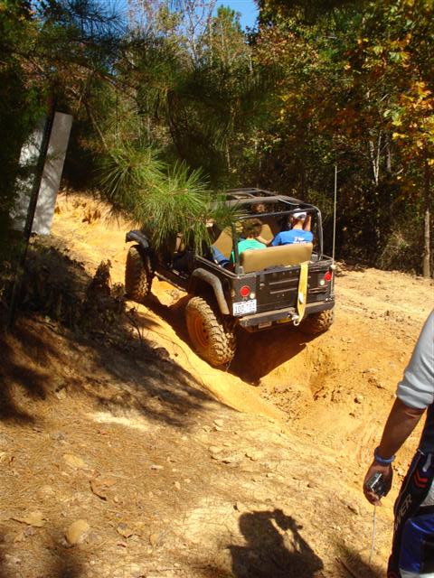 2008 International School Bus - A black Jeep Wrangler navigates a steep, sandy incline during an off-road excursion.