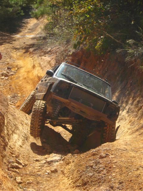 2008 International School Bus - An off-road vehicle navigates a challenging, steep dirt trail with significant articulation.