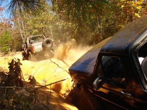 2008 International School Bus - Two vehicles tackle a challenging off-road course, with one vehicle pulling the other with a tow strap.