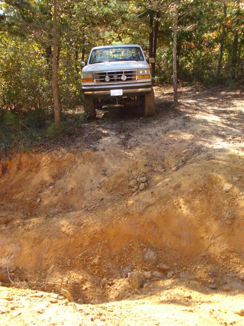 2008 International School Bus - A white pickup truck navigates an off-road incline, its front grille and headlights clearly visible.
