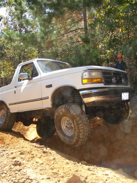 2008 International School Bus - Modified pickup truck navigating an off-road trail.