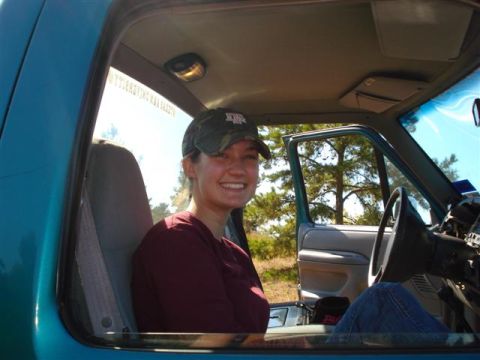 2008 International School Bus - A woman smiles from the passenger seat of a teal pickup truck.