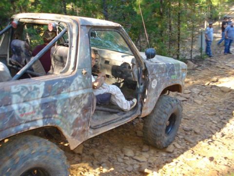 2008 International School Bus - A heavily modified pickup truck with a camouflage paint scheme navigates a rocky trail.