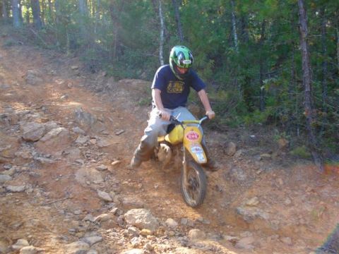 2008 International School Bus - A young rider navigates a steep, rocky trail on a small dirt bike.