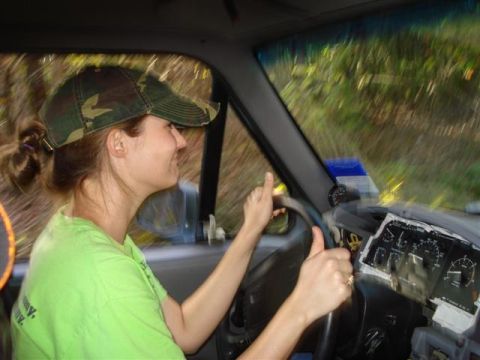 2008 International School Bus - A woman wearing a camouflage hat drives a vehicle, with a view of the dashboard and gauges visible.
