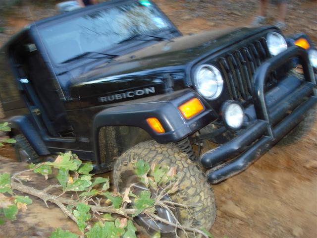 Black Jeep Wrangler Rubicon stuck in mud, front 3/4 view