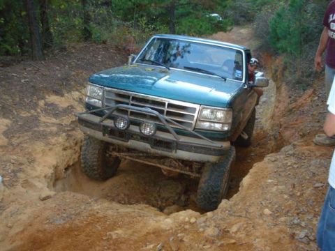2008 International School Bus - Teal Ford F-150 pickup truck navigating a challenging off-road trail.