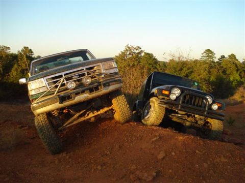 2008 International School Bus - Two off-road vehicles, a Ford F-Series truck and a Jeep Wrangler, navigate a steep, dusty incline.