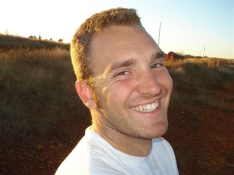 2008 International School Bus - Man smiles in an outdoor setting with dry grass and sky. Supermotors.net logo is present.