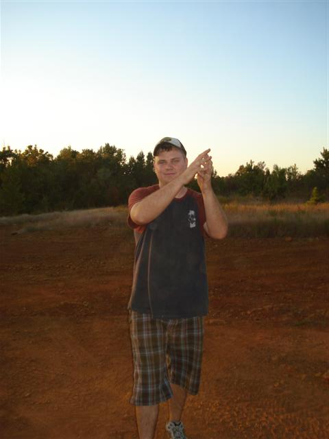 2008 International School Bus - A person stands in a dirt field with trees in the background under a clear sky.