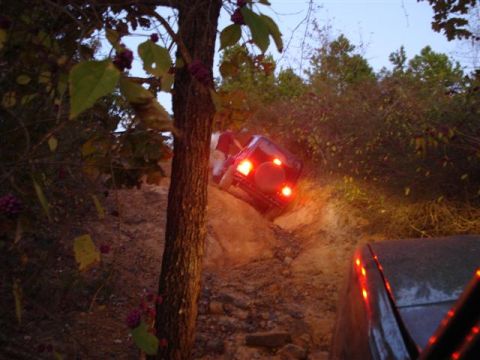 2008 International School Bus - Off-roading adventure on a challenging dirt path with multiple vehicles.