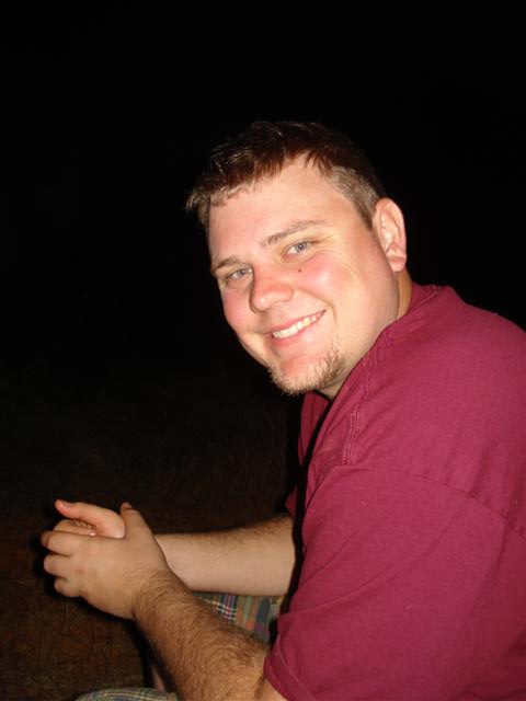 2008 International School Bus - A man smiles for the camera in a dimly lit setting, with the Supermotors logo visible.