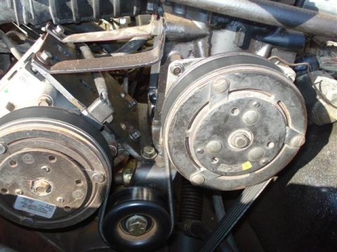 2008 International School Bus - Engine bay detail: AC compressor and associated drive belt components.