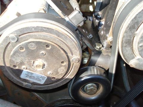 2008 International School Bus - Close-up view of the engine's belt system, including the tensioner and AC compressor.