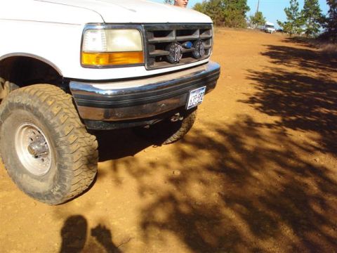 2008 International School Bus - Front view of a white pickup truck with off-road tires and auxiliary lights mounted on the grille.