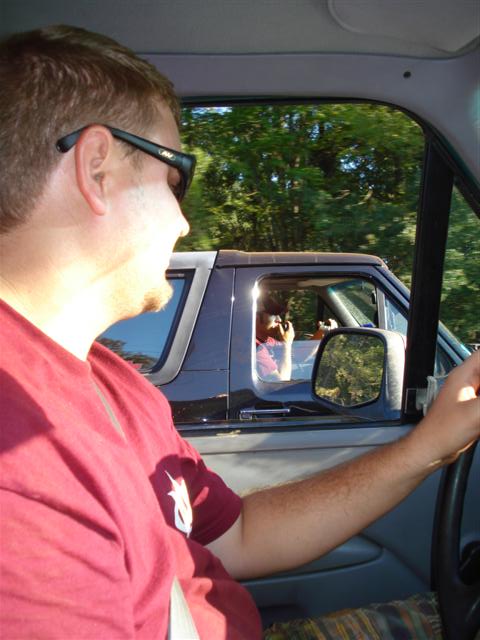 2008 International School Bus - Driver in red shirt looks out window at another vehicle during a drive.