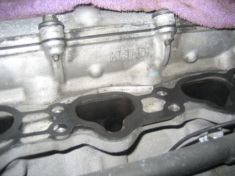 1993 Ford Probe - A close-up view of an engine's intake manifold gasket and surrounding metal components.