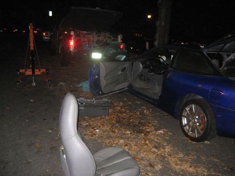 1993 Ford Probe - A blue 1993 Ford Probe is parked at night with its doors open and a car seat removed, next to an engine hoist.