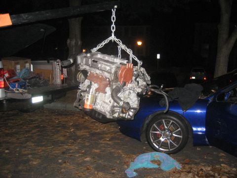 1993 Ford Probe - Engine removal or installation in progress, with a blue car and a pickup truck.