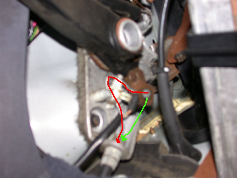 Annotated close-up of vehicle linkage hardware with red and green arrows marking a fitting