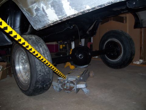 1971 Ford Ranchero - Vehicle's rear axle and suspension are visible while it's supported by a floor jack.