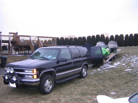 1998 Chevrolet Tahoe - 1998 Chevrolet Tahoe in 3q-front view is seen towing a trailer with snowmobiles.
