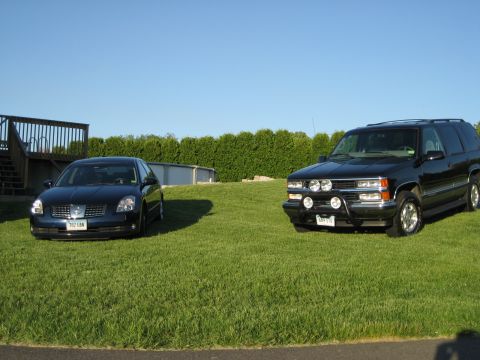 1998 Chevrolet Tahoe - This black 1995 Chevrolet Tahoe is parked on a grassy lawn with a blue sedan.