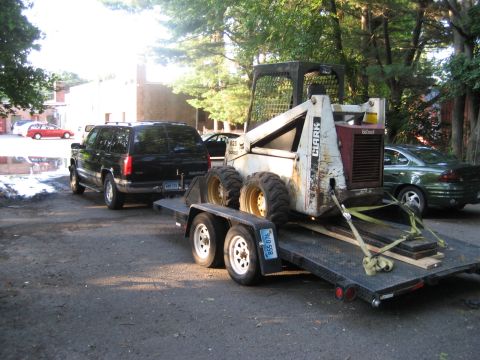 1998 Chevrolet Tahoe - 1998 Chevrolet Tahoe is seen towing a trailer loaded with a skid steer loader.