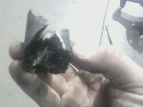 1992 Ford F-350 - A person holds a fragment of what appears to be a damaged mechanical component.