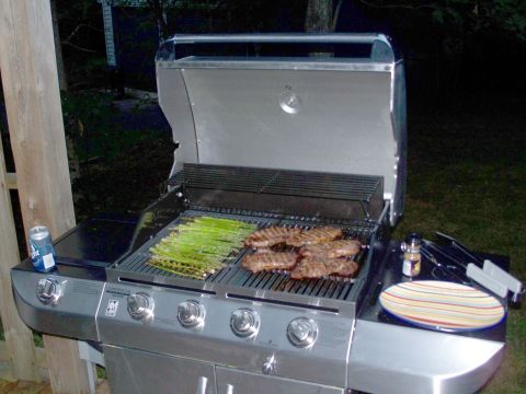 1971 Ford Ranchero - Steaks and asparagus are grilling on a stainless steel gas grill outdoors at night.