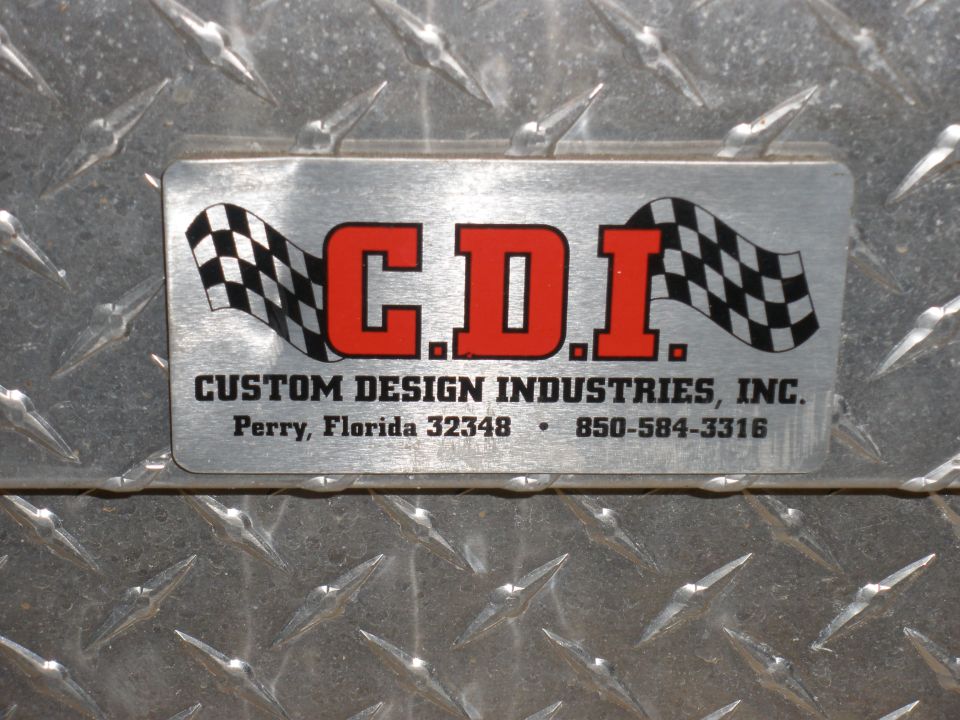 Metal plate with C.D.I. Custom Design Industries, Inc. logo and contact info