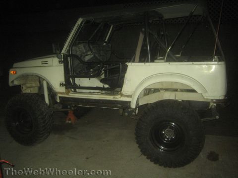 1987 Suzuki Samurai - This modified SUV has a roll cage and is lifted with large tires, suggesting off-road use.