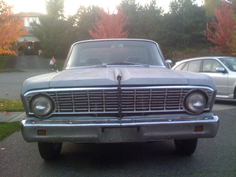 1983 Ford Bronco - A 1963 Ford Falcon sedan is seen from the front, parked in a driveway with autumn trees in the background.