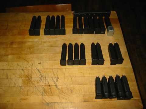 1996 Ford Bronco - Multiple firearm magazines are laid out on a scratched wooden table. The registry incorrectly identifies this as a 1996 Ford Bronco.
