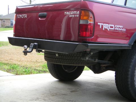 1996 Ford F-150 - Rear view of a red Toyota Tacoma pickup truck with a custom bumper and TRD Off Road badging.