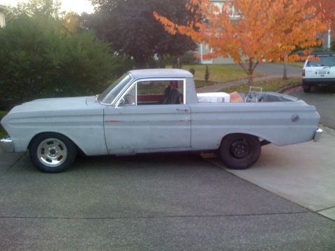 1983 Ford Bronco - This gray pickup truck, likely from the early 1960s, is shown from the side with another vehicle visible in the background.