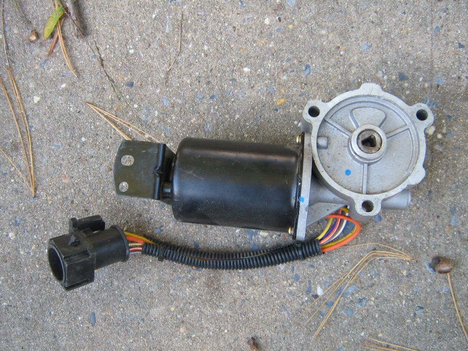 Power window motor assembly with wiring harness and connector, lying on a concrete surface
