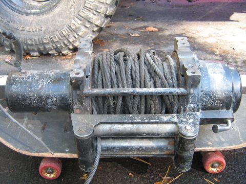 1990 Ford Bronco - A winch and a large tire are shown, mounted on a skateboard.