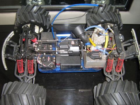 1990 Ford Bronco - The underside of a remote control monster truck shows its engine, suspension, and drivetrain components.