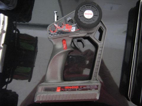 1990 Ford Bronco - A Traxxas remote control transmitter is shown, a steering wheel and trigger for operation.
