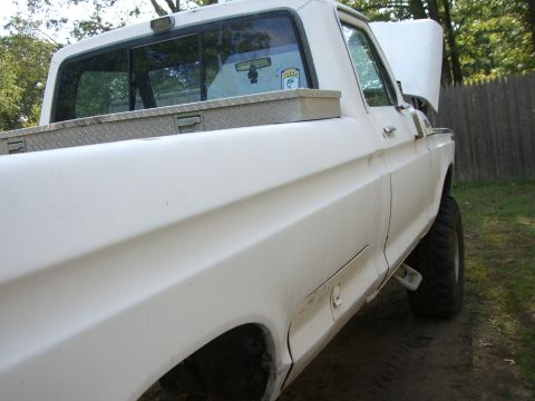 1988 Ford Bronco - This white pickup truck, seen from a 3q-front angle, has its hood open and a toolbox mounted in the bed.