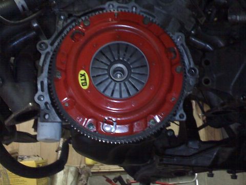 1993 Ford Probe - Close-up view of a vehicle's clutch and flywheel assembly, showing a red clutch cover and a yellow XTD sticker.