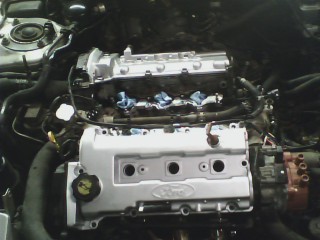 1993 Ford Probe - Engine bay of a Ford vehicle undergoing maintenance, with components exposed.