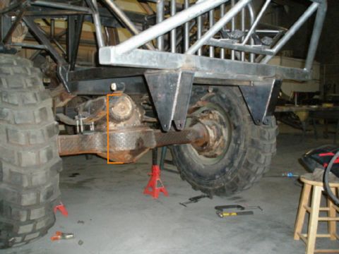 1991 Ford Bronco - Custom vehicle's rear axle and suspension components are visible, with a roll cage structure overhead.
