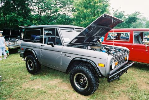 1972 Ford Bronco - Gray 1972 Ford Bronco shown with its hood open at an outdoor event.