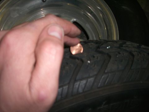 1988 Ford Bronco - A penny is placed on a tire tread, with the Supermotors.net logo visible at the bottom right.