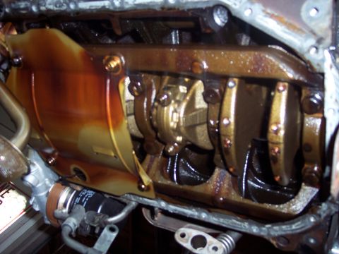 1995 Mitsubishi Eclipse - Close-up view of a vehicle's engine internals, specifically the crankshaft and oil pan area.
