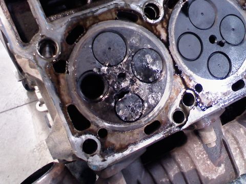 2001 Ford F-350 - This engine part shows significant damage to the valves and surrounding areas, indicating a severe mechanical issue.